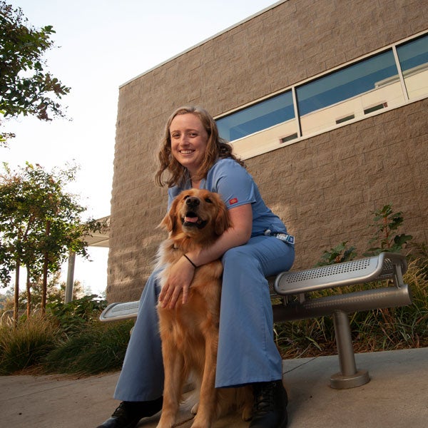A veterinary student cares for a dog outside of the ϲʿͼ School of Veterinary Medicine