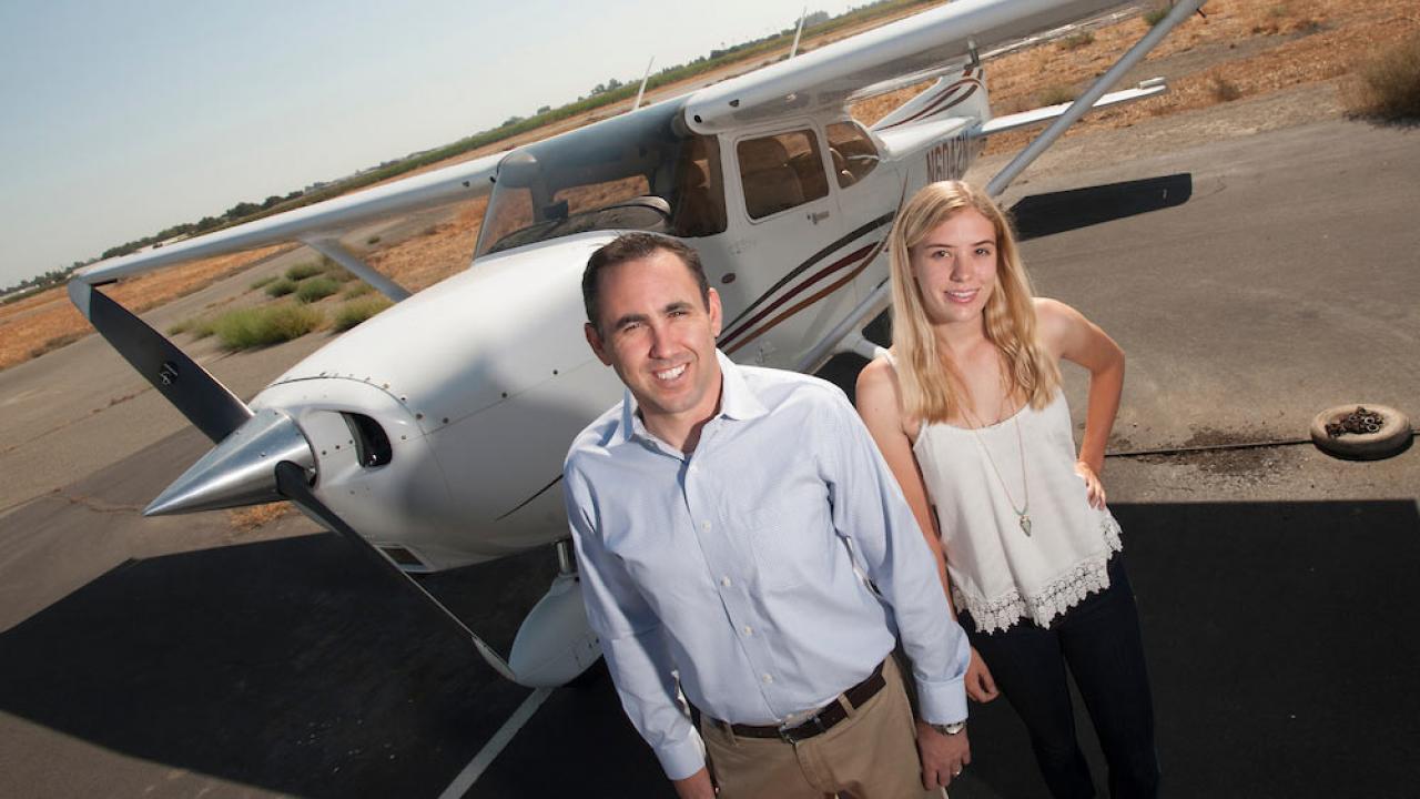 An instructor and student pose for a shot in front of an airplane at ϲʿͼ airport
