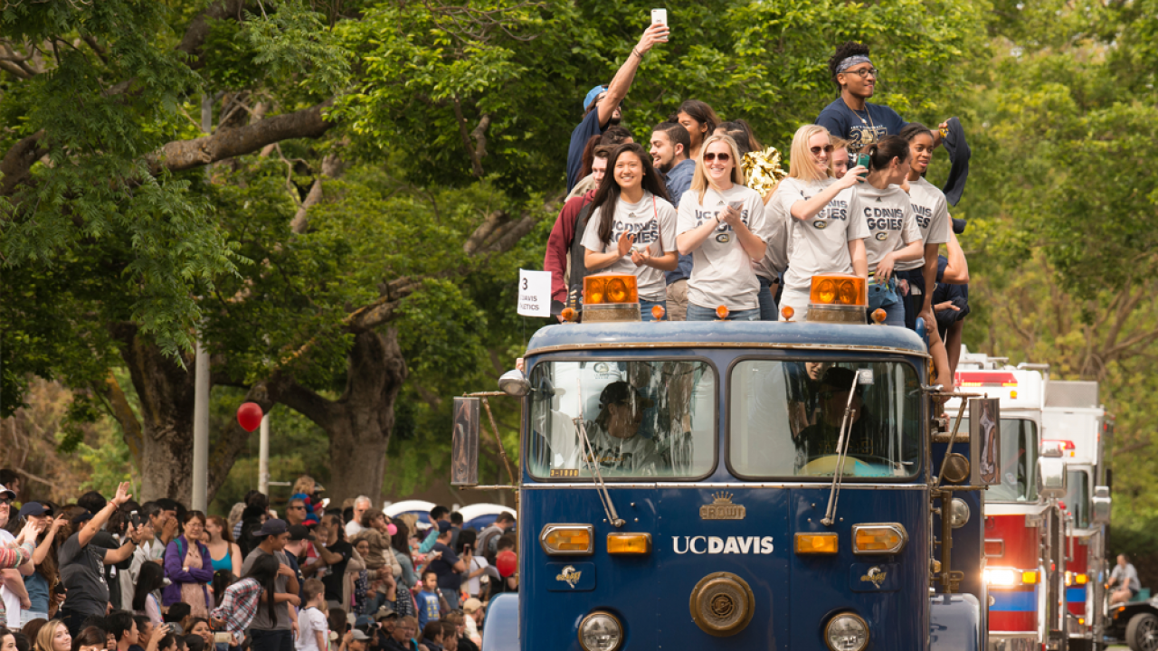 ϲʿͼ students ride on top of a ϲʿͼ branded blue fire engine during the picnic day parade