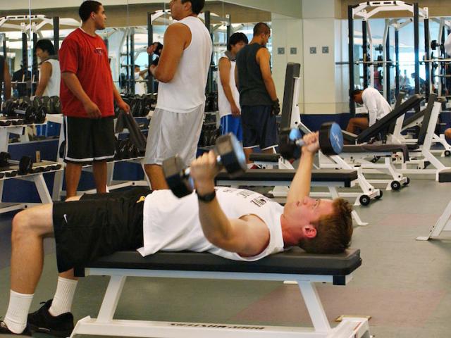 A male student works out in the ϲʿͼ Activities and Recreation center weight room