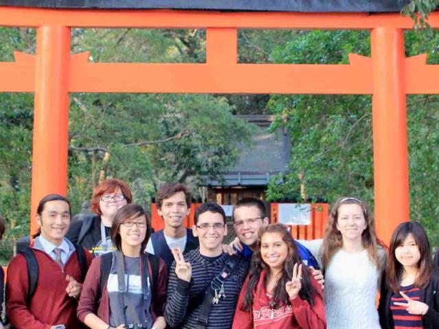 ϲʿͼ students pose in front of a shinto shrine in japan.