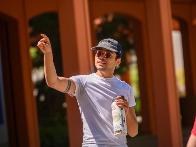 A tour guide pointing out a ϲʿͼ campus landmark