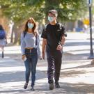 Students with masks walk through the sunlit ϲʿͼ campus.